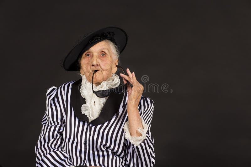 Παλαιό grandma σε ένα άσπρος-μαύρο ριγωτό σακάκι στοκ φωτογραφίες